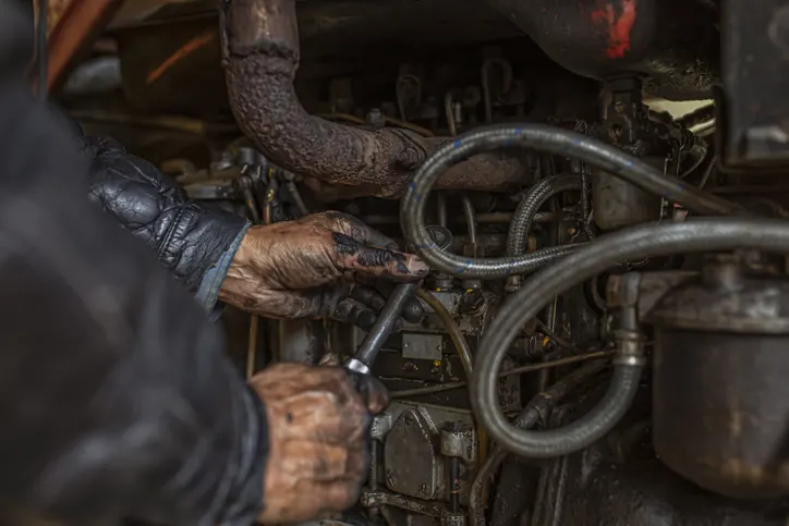 Diesel engine repair, diagnostics, and rebuilds at Bledsoe Truck & Trailer Repair — Oklahoma City A diesel mechanic's grease-stained hands working on a Bledsoe truck engine — heavy-duty diesel repair in Oklahoma City performed by certified technicians.
